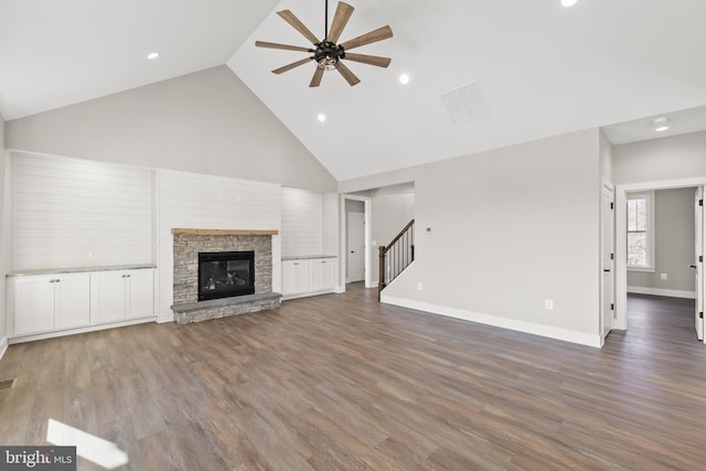 unfurnished living room featuring ceiling fan, a fireplace, high vaulted ceiling, and dark wood-type flooring