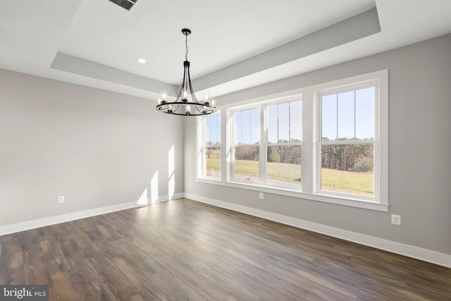 unfurnished dining area with dark hardwood / wood-style floors, an inviting chandelier, and a healthy amount of sunlight