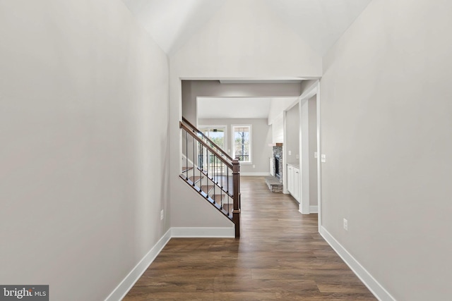 hall with dark hardwood / wood-style flooring and vaulted ceiling