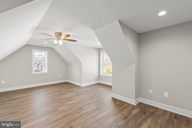 additional living space featuring hardwood / wood-style floors, vaulted ceiling, plenty of natural light, and ceiling fan