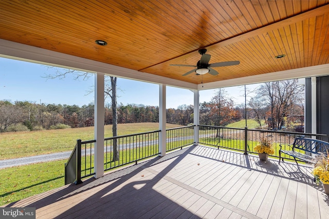 deck featuring ceiling fan, covered porch, and a yard