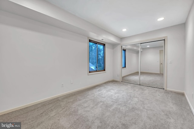 unfurnished bedroom featuring light carpet and a closet