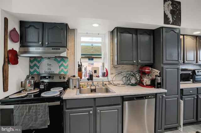 kitchen with tasteful backsplash, gray cabinetry, appliances with stainless steel finishes, and sink