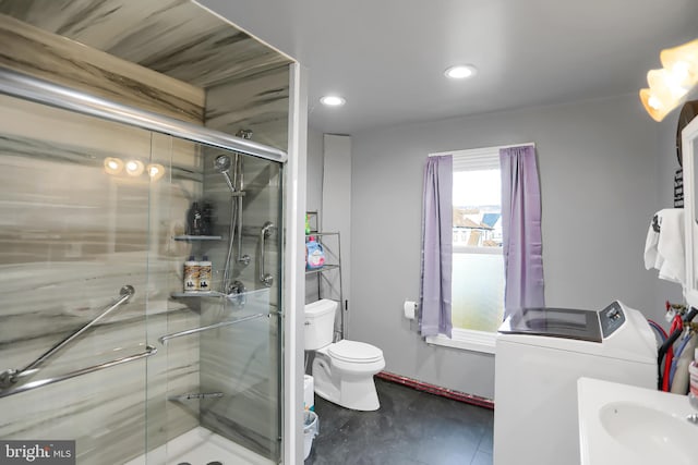 bathroom featuring toilet, sink, an enclosed shower, and washing machine and clothes dryer