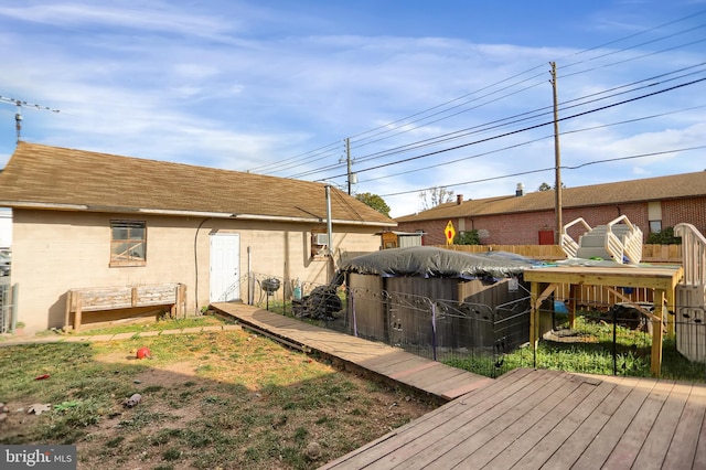 rear view of property featuring a swimming pool side deck