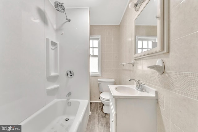 full bathroom with shower / bath combination, wood-type flooring, toilet, tile walls, and vanity