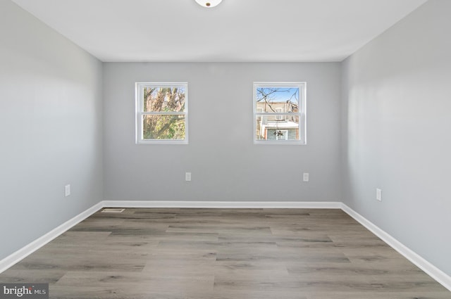 empty room with plenty of natural light and light hardwood / wood-style floors