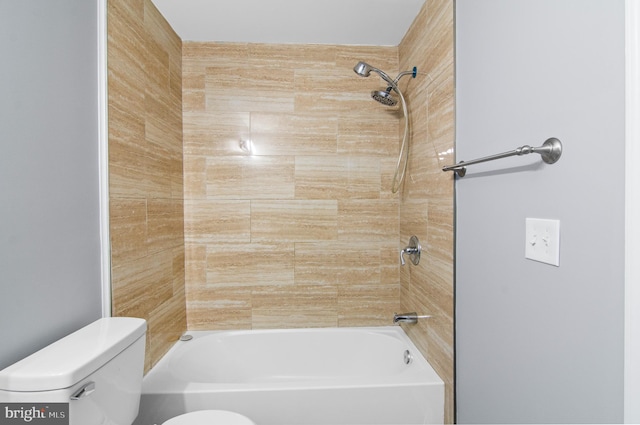 bathroom featuring tiled shower / bath and toilet