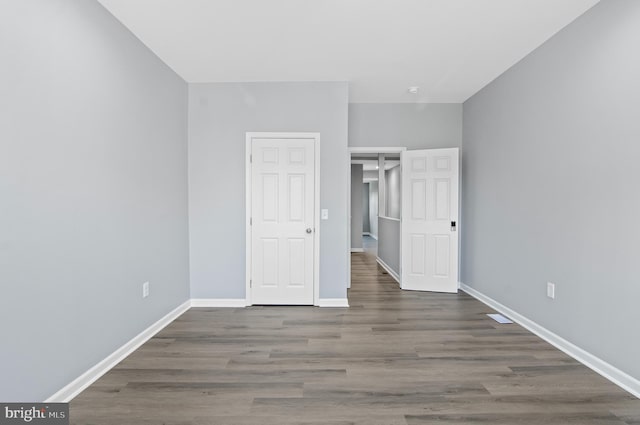 unfurnished bedroom with dark wood-type flooring