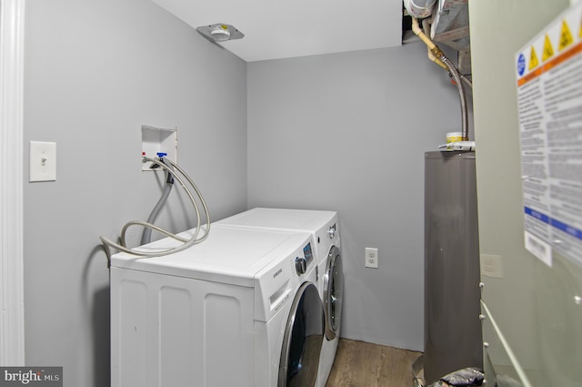 laundry room with water heater, washer and dryer, and light hardwood / wood-style flooring