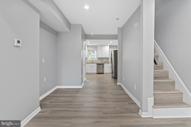 1106 Mckean Ave, Baltimore, MD 21217 - hallway featuring stairs, light wood finished floors, baseboards, and recessed lighting