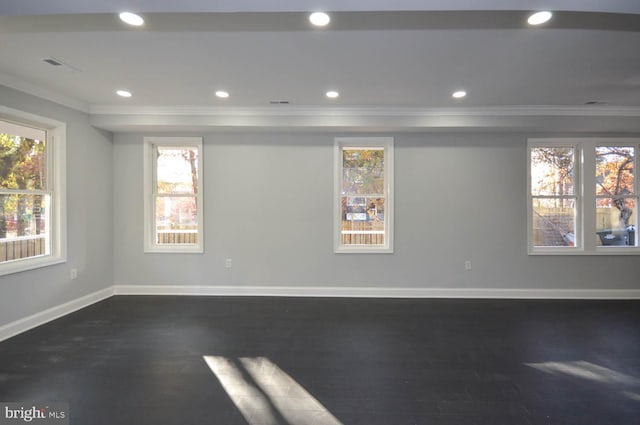 spare room featuring ornamental molding and dark hardwood / wood-style floors