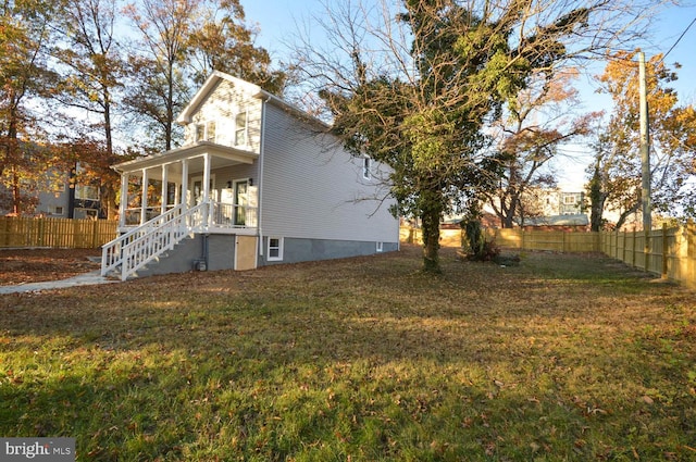 view of side of home featuring a lawn and a porch