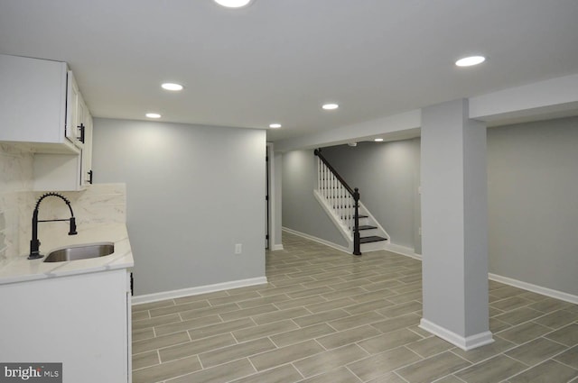 basement with sink and light hardwood / wood-style flooring