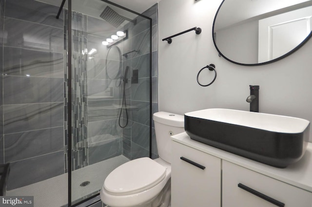 bathroom with vanity, toilet, and a shower with door