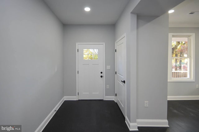 doorway with dark wood-type flooring and crown molding