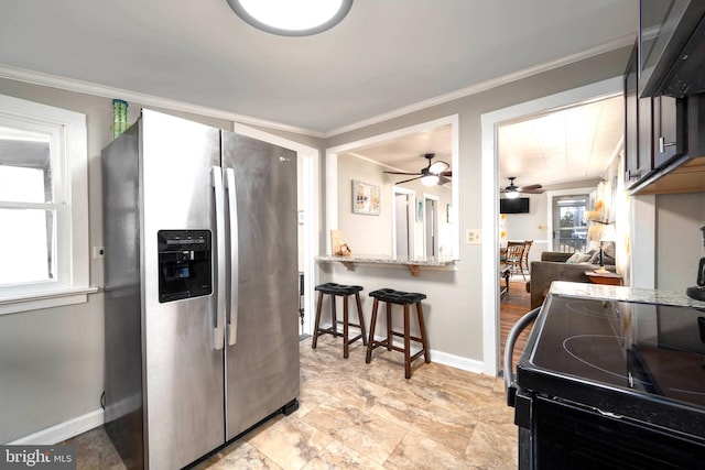 kitchen featuring stainless steel refrigerator with ice dispenser, range, light stone counters, and crown molding