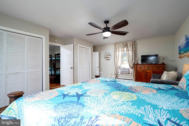 bedroom with hardwood / wood-style flooring, multiple closets, cooling unit, and ceiling fan