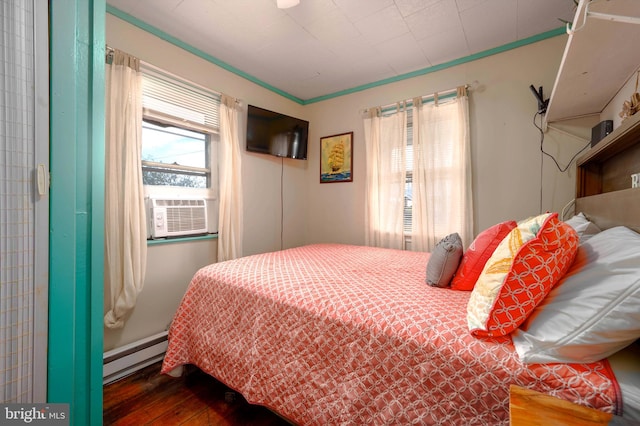 bedroom featuring a baseboard heating unit, wood-type flooring, and cooling unit