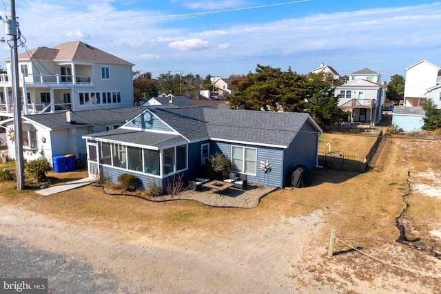 rear view of house with a sunroom and a balcony