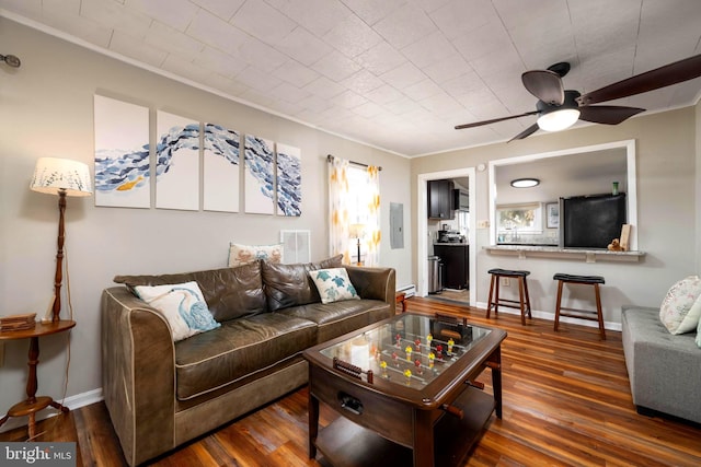 living room featuring dark hardwood / wood-style flooring, ceiling fan, electric panel, and ornamental molding