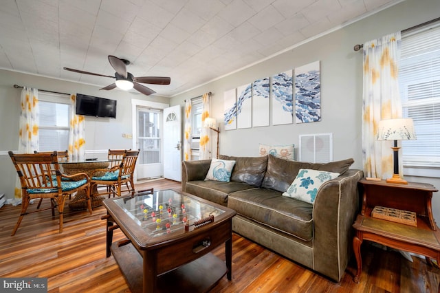 living room featuring ceiling fan, wood-type flooring, and ornamental molding