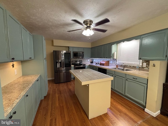 kitchen with dark hardwood / wood-style floors, a center island, decorative backsplash, and appliances with stainless steel finishes