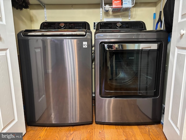 clothes washing area featuring washer and dryer and light hardwood / wood-style floors