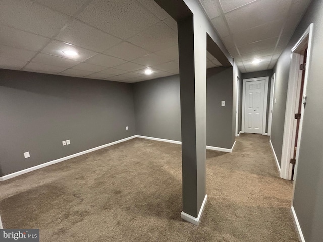 basement featuring carpet and a drop ceiling