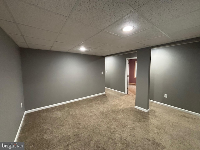 basement with carpet flooring and a paneled ceiling