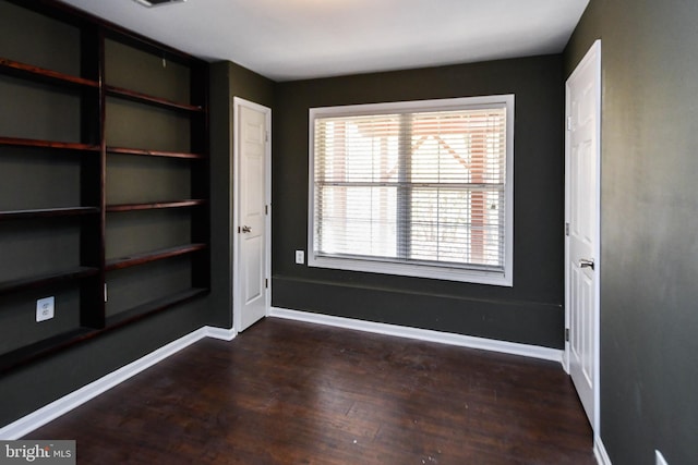 empty room with dark hardwood / wood-style flooring