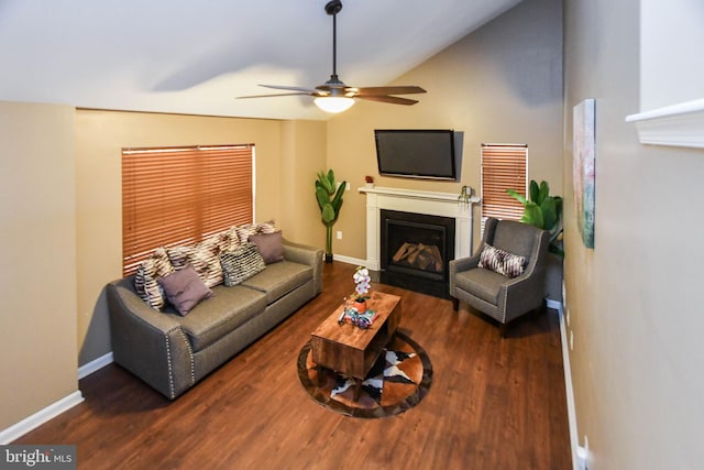 living room with dark hardwood / wood-style flooring, ceiling fan, and vaulted ceiling