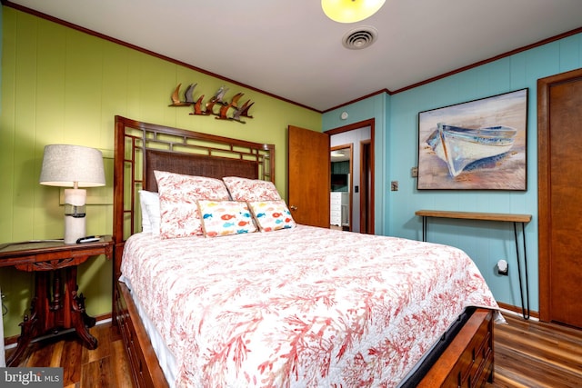 bedroom with dark hardwood / wood-style floors and ornamental molding