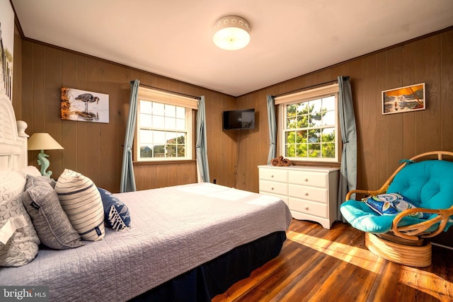 bedroom with wood-type flooring and wood walls