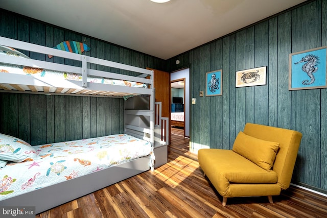 bedroom with wood walls and wood-type flooring