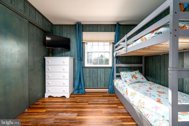 bedroom featuring wood-type flooring and wooden walls