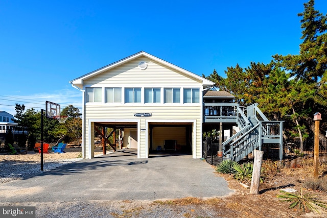 view of front of house featuring a sunroom, a garage, and a carport