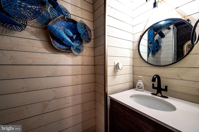 bathroom with vanity and wooden walls