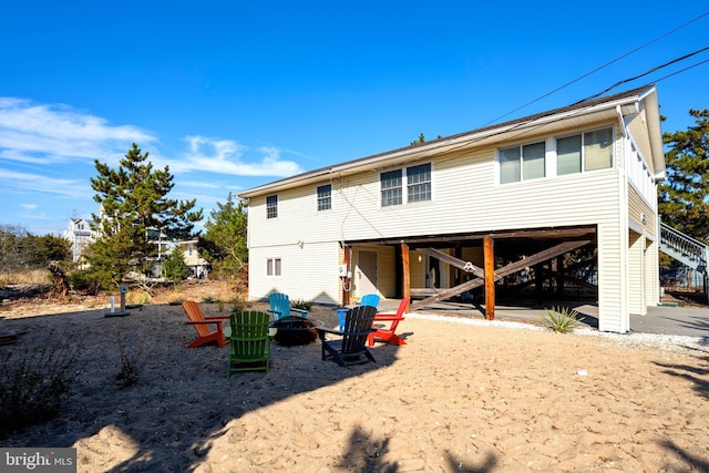 back of property with an outdoor fire pit