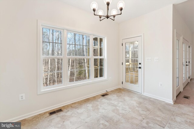 unfurnished dining area featuring a chandelier