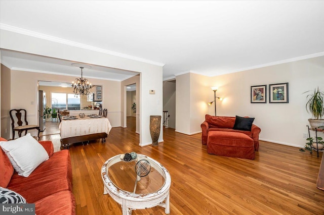 bedroom featuring stainless steel refrigerator, a notable chandelier, ornamental molding, and wood-type flooring