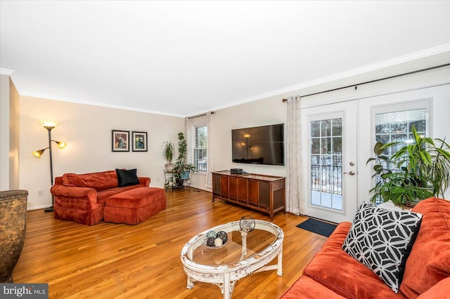 living room with french doors, hardwood / wood-style floors, and crown molding