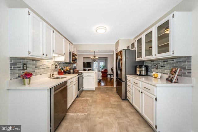 kitchen featuring sink, white cabinets, appliances with stainless steel finishes, and decorative backsplash