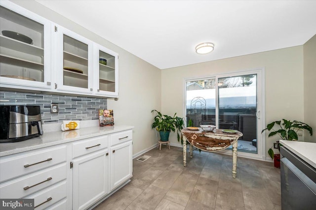 kitchen with white cabinets, light hardwood / wood-style floors, and decorative backsplash