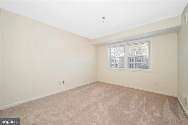 unfurnished room featuring light carpet