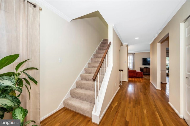 stairs featuring hardwood / wood-style flooring and crown molding