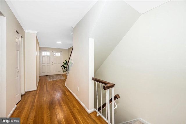 corridor with hardwood / wood-style flooring and ornamental molding