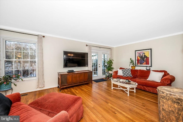 living room featuring ornamental molding, french doors, and light hardwood / wood-style flooring