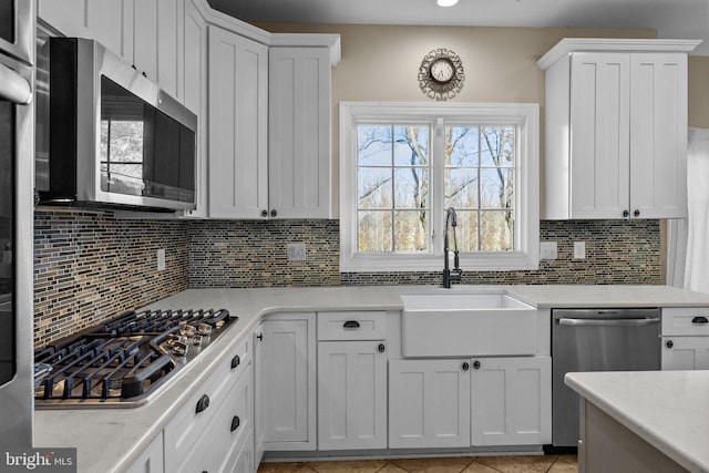 kitchen featuring white cabinets, appliances with stainless steel finishes, sink, and light tile patterned flooring