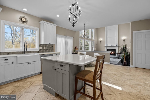 kitchen featuring a healthy amount of sunlight, white cabinetry, decorative light fixtures, and a center island